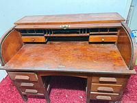Front view of wooden secretary desk showing writing surface and cubbies