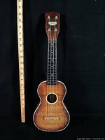 Front view of Harmony soprano ukulele beside ruler