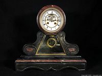 Front view of mantle clock showing case and dial
