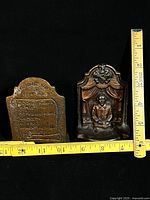 Front and back of one bookend with tape measure showing height ~5.25 in