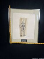 Full view of framed drawing with measuring tape for scale