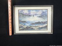 Front view of framed watercolor seascape with ruler for scale