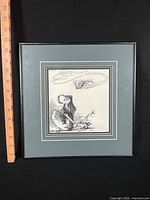 Frontal view of framed cartoon showing full artwork and ruler for scale