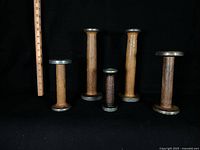 All five spools upright beside ruler for scale