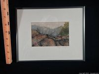 Front view showing watercolor landscape, mat and metal frame with ruler for scale