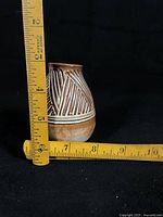 Front view of vase with measuring tape showing height