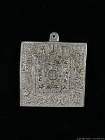 obverse of square pendant showing detailed relief zodiac and Buddhist motifs