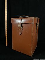 brown leather case closed beside ruler