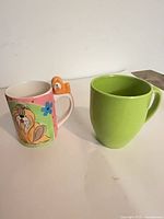 Dog motif mug and lime green mug side by side