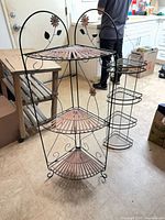 Large and small wrought iron corner shelves standing together