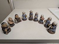Front view of all nine figurines aligned on table