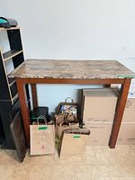 Full view of tall table with faux marble top and wood legs