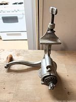 Side view of entire clamp-on meat grinder showing wooden handle and clamp screw