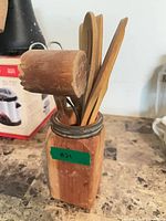 Wooden holder with utensils and scissors visible