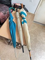 Three umbrellas lying on table showing full length and colors