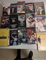 Group shot of 13 VHS tapes showing titles such as Primary, The Birdcage, Citizen Kane, La Dolce Vita, Singin’ in the Rain, West Side Story, My Fair Lady