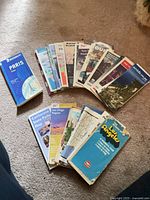 Group of assorted folded maps spread on carpet