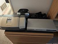 Overall view of printer, boombox, DVD player on dresser