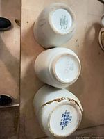 Three cups upside down showing all maker’s marks