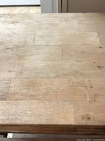 Close view of butcher-block style wooden top showing wear