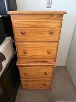 Two small natural wood cabinets stacked, showing overall appearance and four drawers