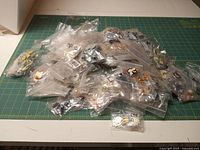 Pile of sealed plastic bags containing numerous enamel pins