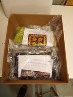 Box containing multiple sealed quilt kits, top labels visible