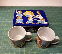 Top view of Tetley tin with two mugs
