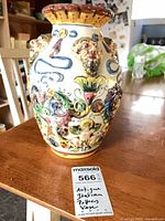 Front view of majolica vase showing relief cherubs and masks