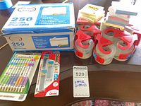 Group shot of envelopes box, tape rolls, Post-it pads, pencils and refills