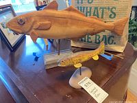 Both carved wooden fish on stands displayed together