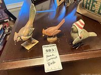 Front view of all three carved wood bird figurines