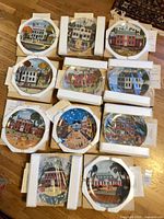 All 11 plates in boxes, some unwrapped, certificates visible