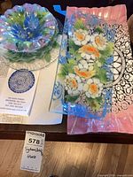 Group view showing round ruffled bowl, rectangular blue-bordered floral plate and Sydenstricker brochure