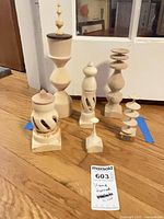 Full group of six unfinished turned wood spindles on floor