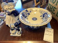 Pedestal plate, kissing couple figurine and child with dog figurine grouped