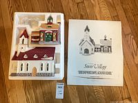 Styrofoam insert with chapel, school building and light cord; outer sleeve shown beside packaging