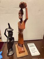 Both wooden figurines side by side showing size comparison