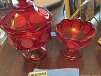 Both ruby red pressed glass compotes side by side