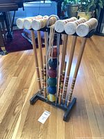 Full view of croquet set on stand showing mallets, balls and wickets