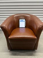 Front view of brown faux leather swivel barrel chair