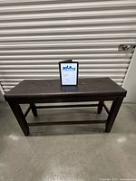 Full bench front view showing padded seat and wood legs