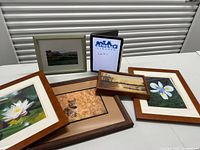 All five framed artworks laid out on table