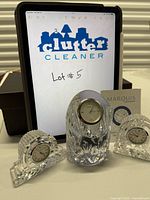 All three crystal desk clocks in front of tablet showing lot number