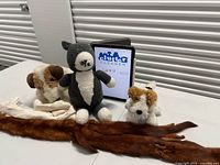 Group shot of all items: three plush animals, two fur stoles, cream scarf