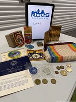 Group shot of all items including coins, patches, clutch, cigarette case, trinket box