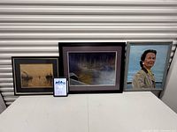 Three framed artworks side by side