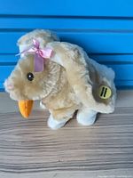 Front view of tan plush bunny with carrot and pink bow