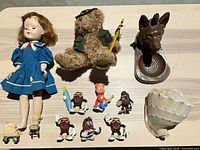 Group shot of doll, bear, ashtray, figurines, shell, mini prams