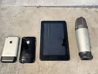 Four electronics items lined up: two iPhones, Kindle Fire tablet, USB microphone